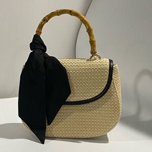 A New Day Woven look Tan and Black Clutch with Bamboo Accent Handle and Tie.